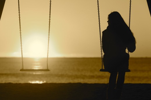 Single Woman Alone Swinging On The Beach